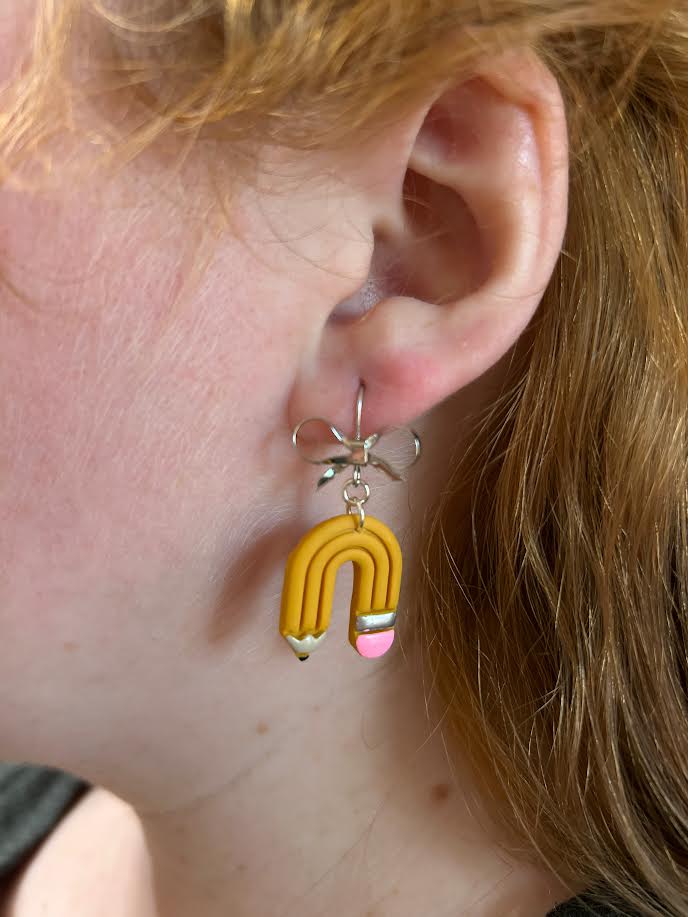 Creative and playful polymer clay earrings with bow detail on French wire hooks