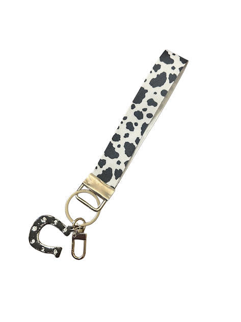 Western-inspired wristlet keychain with cow print and polymer clay horseshoe