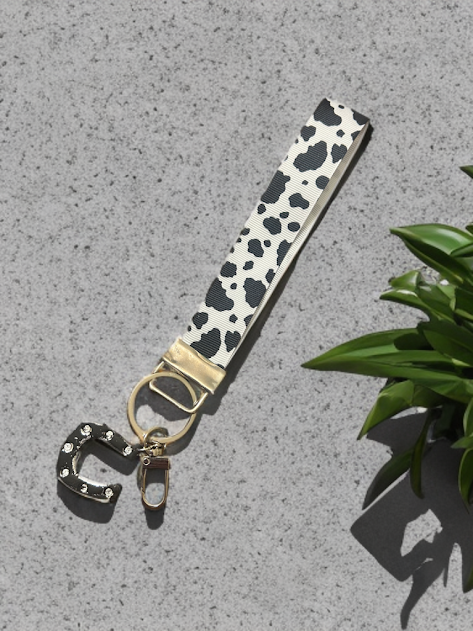 Cow print ribbon wristlet keychain with black polymer clay horseshoe charm and silver foil accents