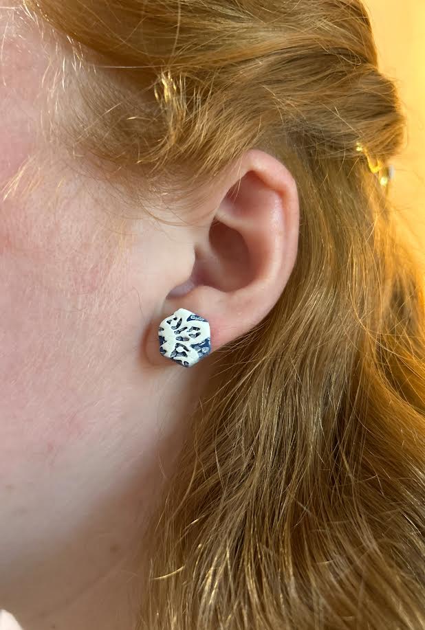 Close-up of vintage-inspired polymer clay stud earrings, denim and lace pattern