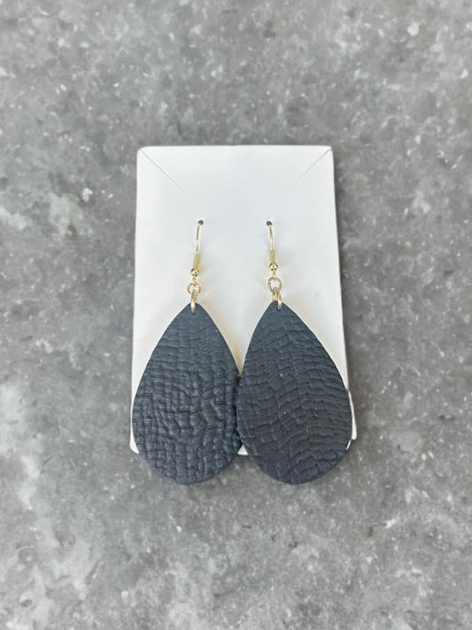 Pair of black leather looking teardrop polymer clay earrings on a white card against a gray background