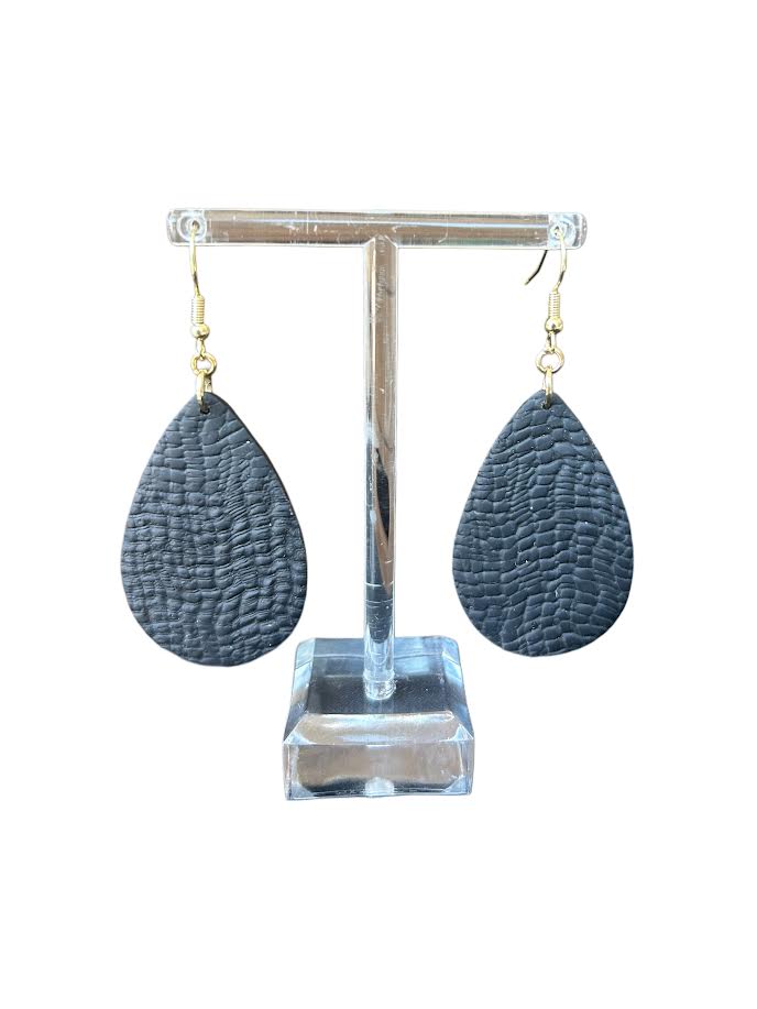 Black leather looking teardrop polymer clay earrings hanging on an acrylic stand.