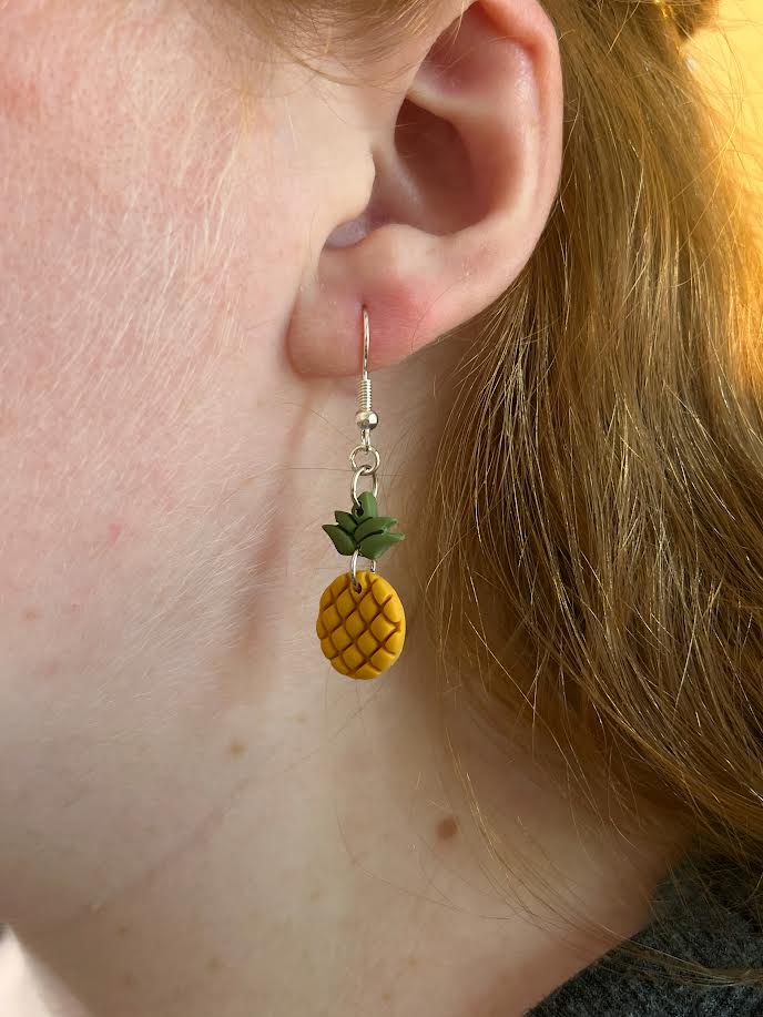 Close-up of a person wearing these lightweight handmade pineapple earrings, perfect for everyday wear