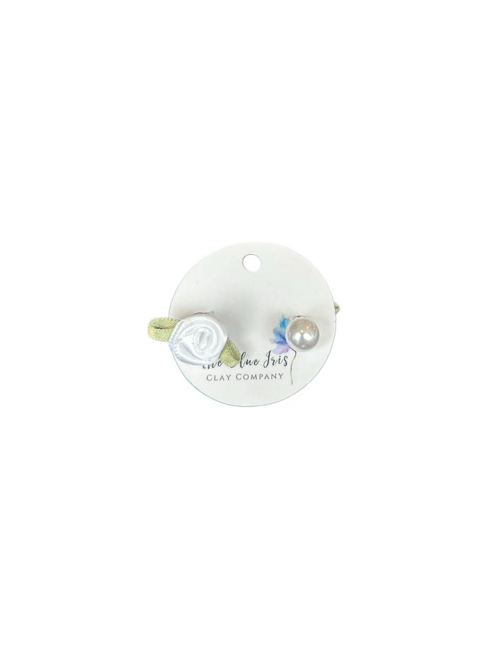Close-up of fabric rose stud earring paired with elegant pearl design